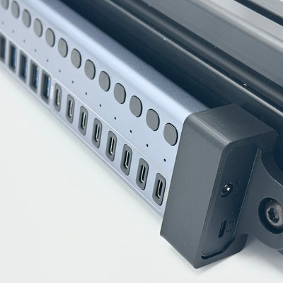Acasis Mount detail showing the bracket connection to an aluminium profile sim racing cockpit. Designed for the HB16Pro and HB16Max USB hubs, the holder gives the hub a dedicated place on the rig and supports organised cable routing around the frame. This mounting detail shows how the hub becomes part of the cockpit layout, with connections grouped near the racing accessories they serve.