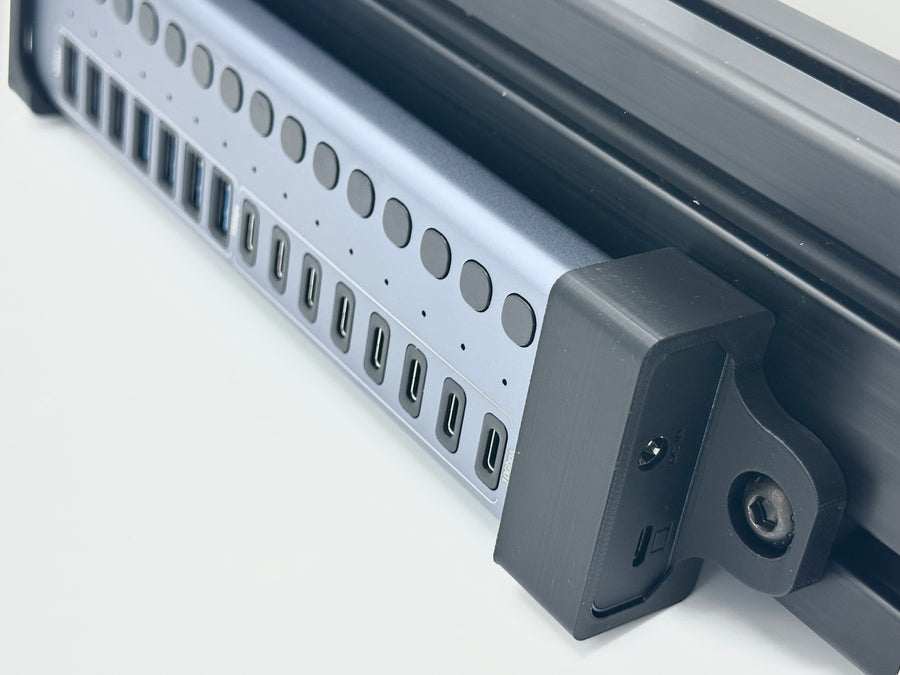 Acasis Sim Racing Mount holding an HB16Pro or HB16Max USB hub on an aluminium extrusion cockpit. The bracket gives the hub a fixed position beside the rig, bringing USB connections together for a neater cable layout. Designed for sim racing cable management, this Acasis mount helps organise wiring from compatible pedals, shifters, button boxes and other USB accessories around the cockpit.