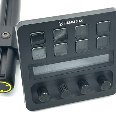 Stream Deck Plus mount installed on a Fanatec ClubSport GT Cockpit, shown beside the steering wheel. The Elgato Stream Deck Plus is angled toward the driver, putting 8 LCD keys, 4 rotary dials, and a touchstrip within easy reach for race controls, voice comms, and stream management. A premium, purpose-built sim racing accessory connected via a RAM Mount adjustable arm. 